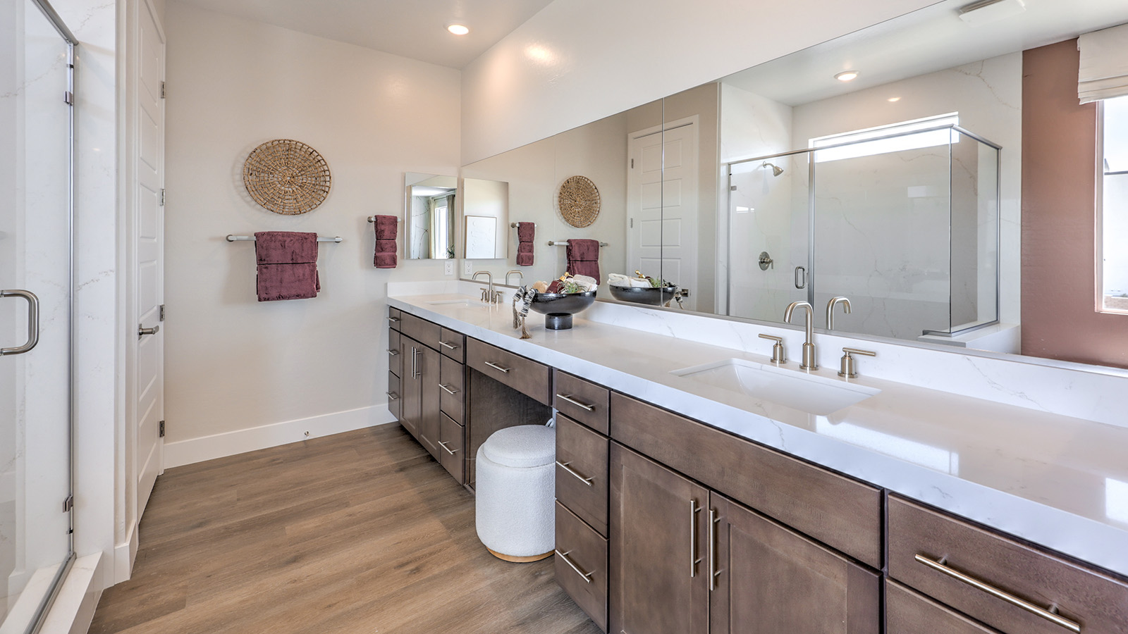 Attached to the Bedroom One Suite, our 4418 model bathroom with granite countertops at the double Bath Vanity, a walk-in closet, mirror, and brown cabinets.
