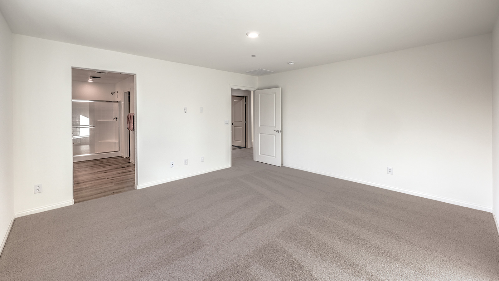 The Bedroom One Suite in our Tropical Falls 2436 model with carpet flooring, recessed ceiling lights, and a window.
