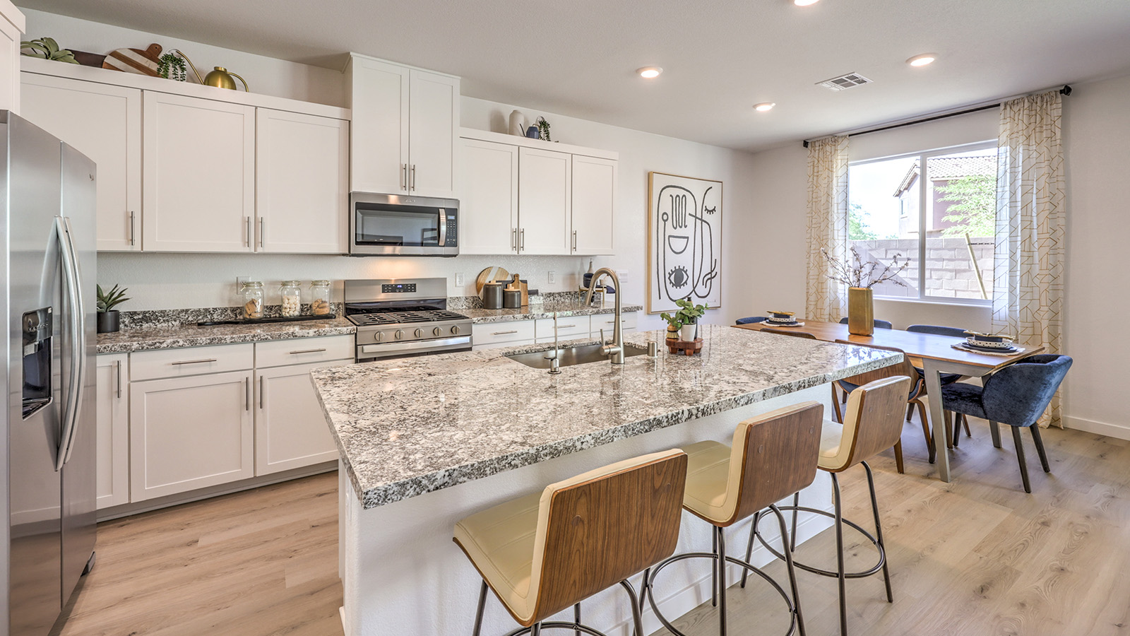 Our 2660 model kitchen in the Tropical Falls Community with white shaker style cabinets, Quartz countertops, a kitchen island, and Whirlpool Stainless Steel appliances.