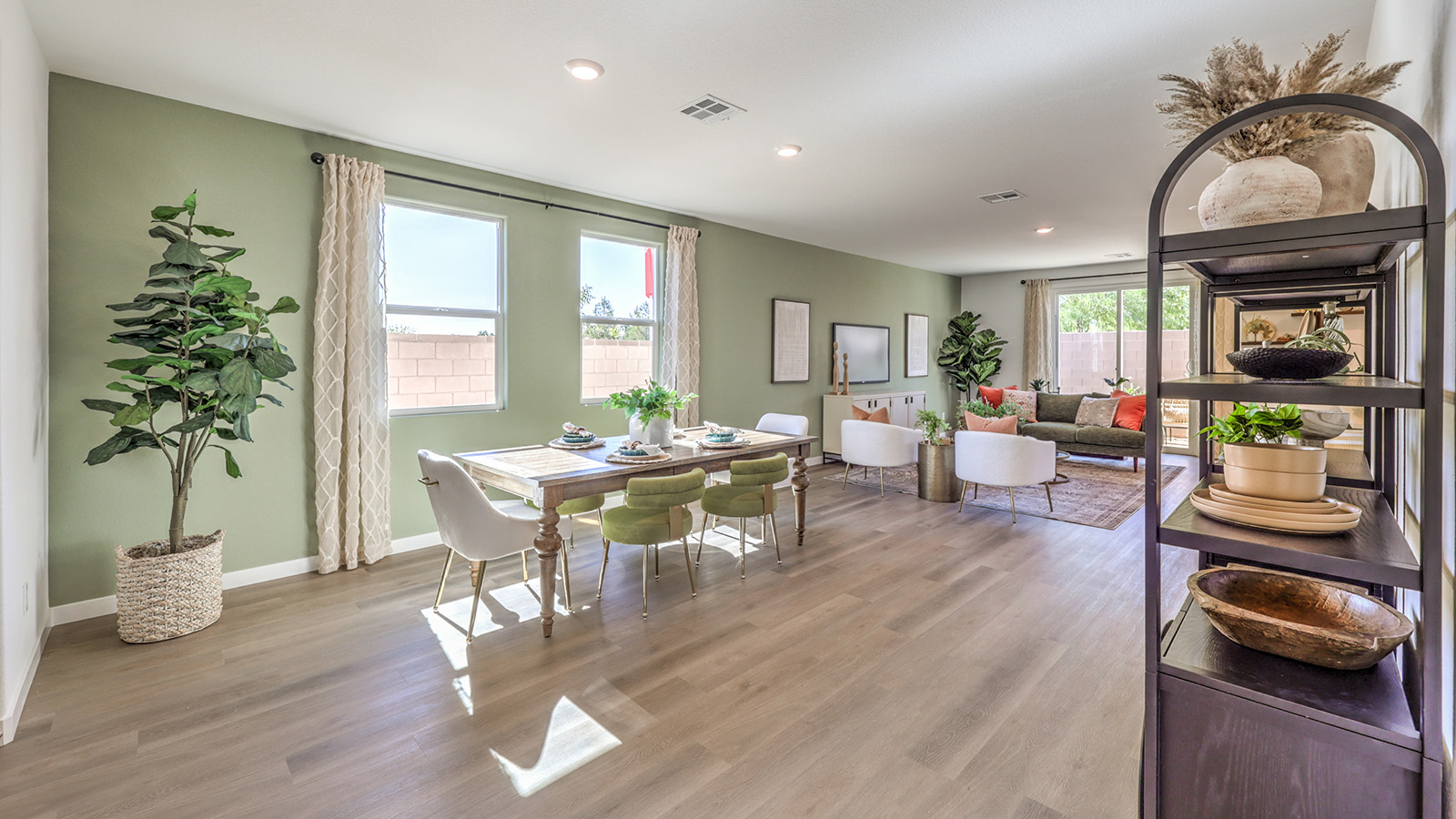 The Tropical Falls 3000 Model open concept Dining Room and Great Room with Luxury Vinyl Plank flooring throughout, featuring expansive windows and a sliding glass door that provide natural light and access to the backyard. The space includes a designated dining area and a spacious living area, designed for seamless flow and functionality.