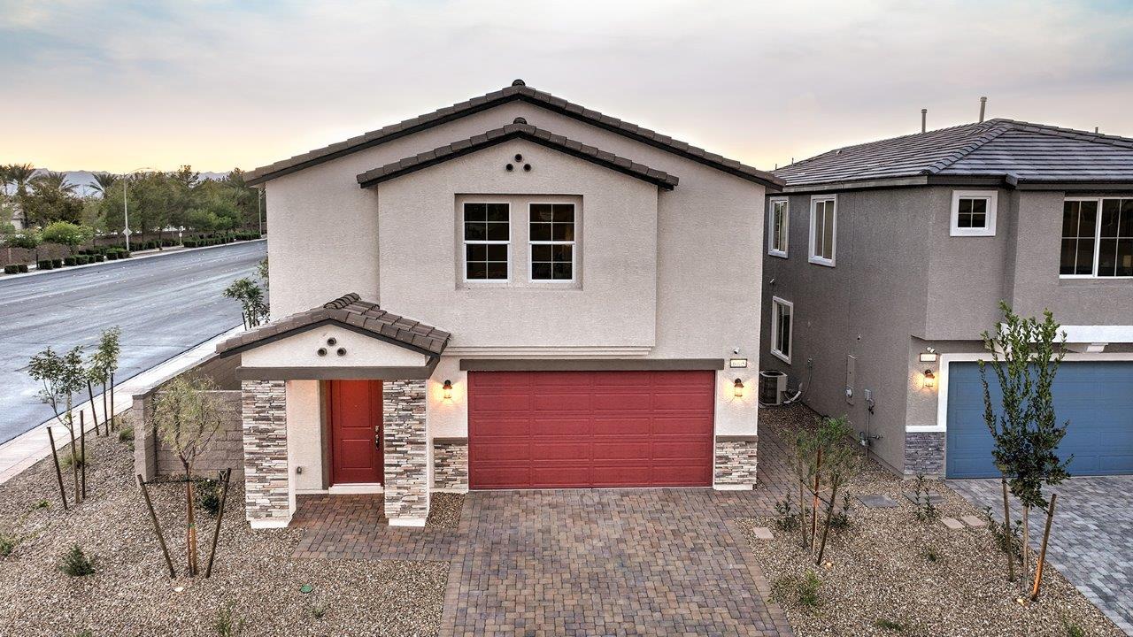 Our 3000 model home in the Tropical Falls community with white and red exterior paint schemes, a flat tile roof, front yard landscaping, 2-car garage, and paver walkways.
