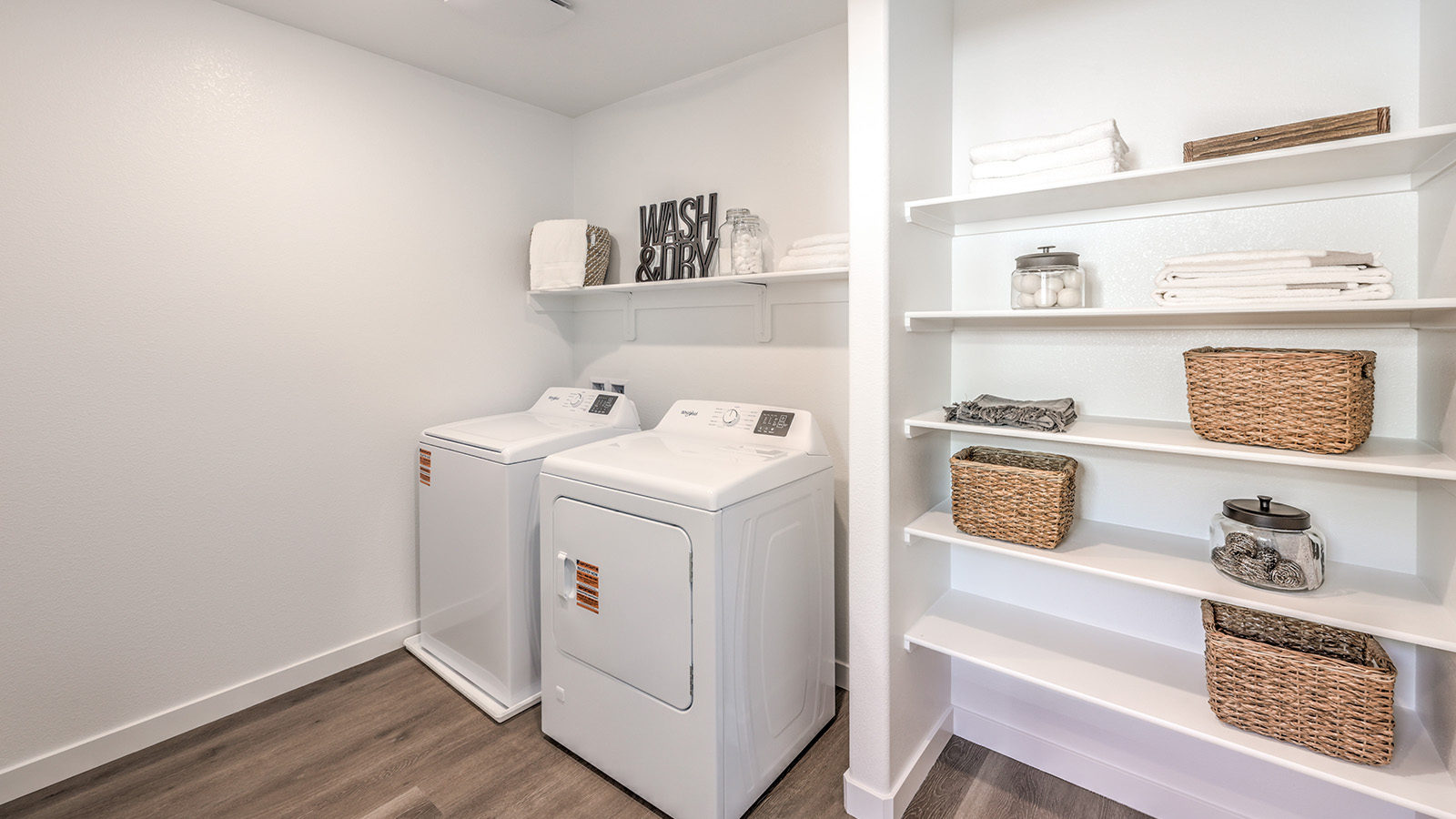 Our Meranto Bay 1802 model laundry room with shelves and a washer and dryer.