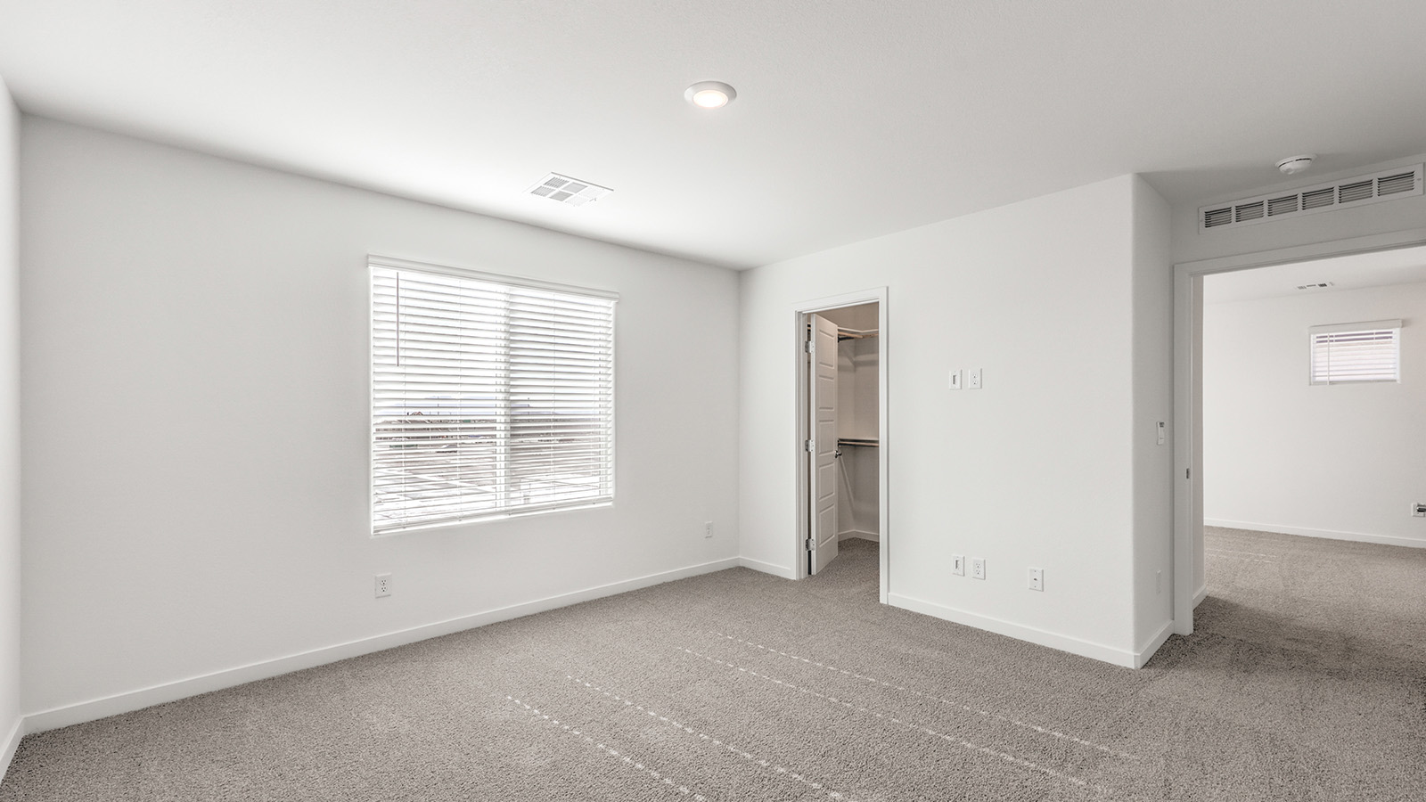 Bedroom Two in our Heartland Cottage 1550 model with carpet flooring, a sliding closet, and one window.