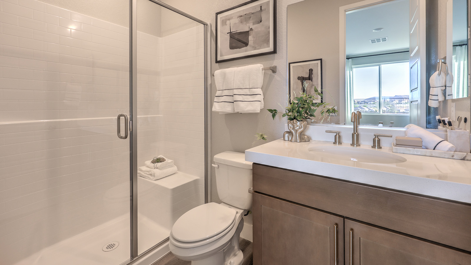 The Majestic Hills 2390 Plan Bathroom 3 featuring Luxury Vinyl Plank flooring, a granite countertop vanity with undermount sink, and a combination tub and shower with white tile surround. A high transom window allows natural light while maintaining privacy, making this bathroom both functional and inviting for guests or family members.