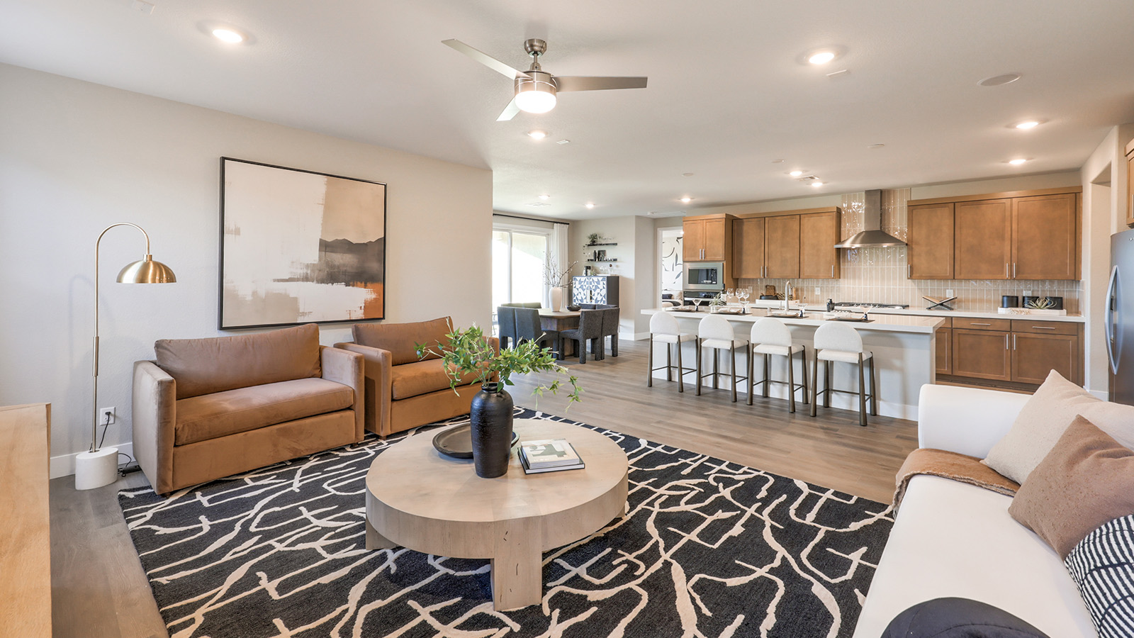 The Majestic Hills 2390 Plan Great Room featuring Luxury Vinyl Plank flooring, a modern ceiling fan, and a large sliding glass door that opens to the backyard. This spacious and open layout offers abundant natural light and seamless flow to adjoining areas, ideal for everyday living and entertaining.