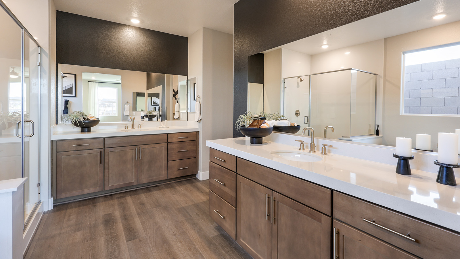 The Majestic Hills 2390 Plan Main Bedroom Suite Bathroom featuring Luxury Vinyl Plank flooring, granite countertops at the dual-sink vanity, and direct access to large walk-in closets. This spacious bathroom offers modern functionality with ample storage and natural light, creating a private and relaxing retreat.