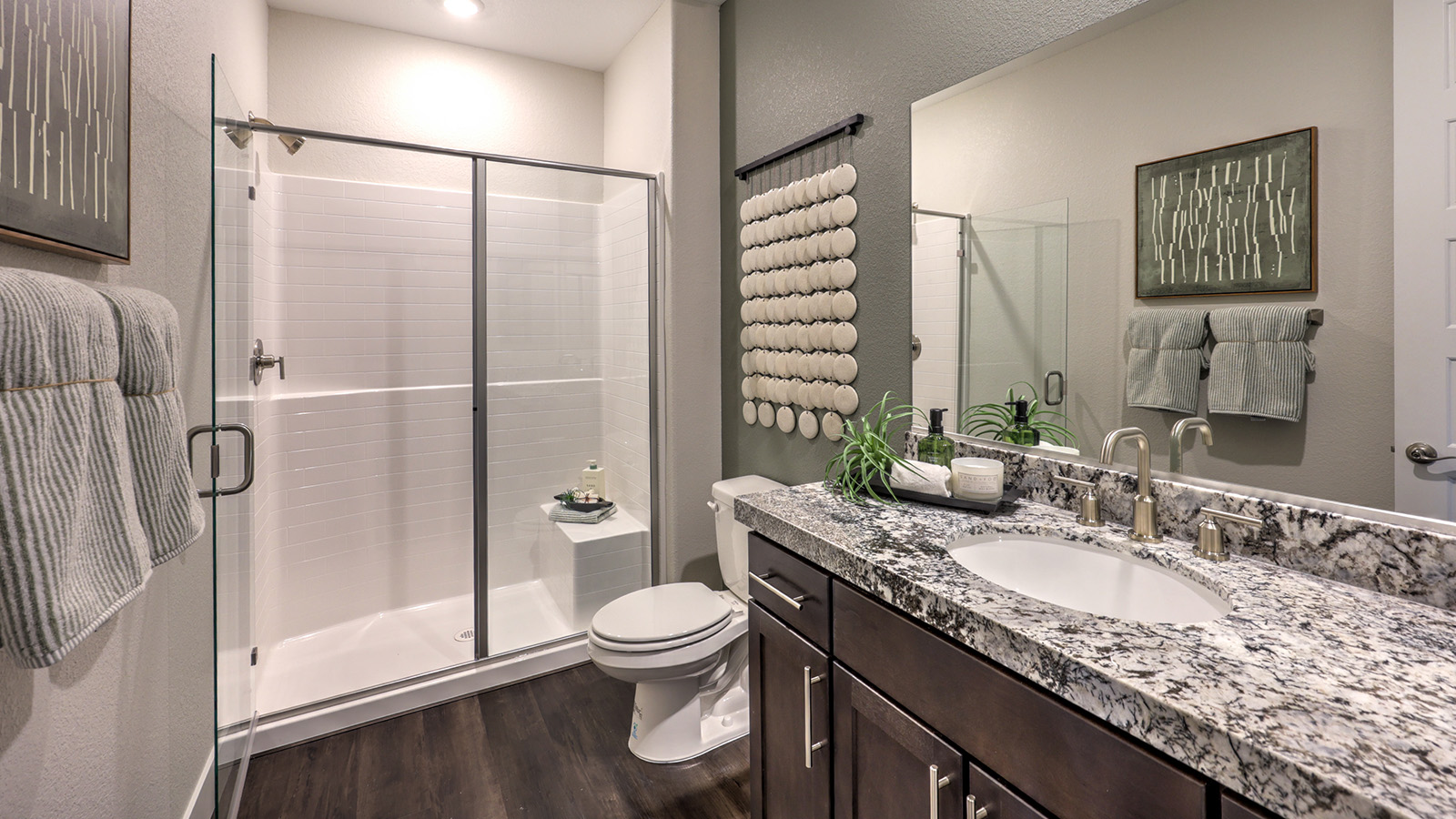 The Majestic Hills 2650 Plan Bathroom 2 featuring Luxury Vinyl Plank flooring, a granite countertop vanity with an undermount sink, and a combination tub and shower with white tile surround. A transom window above the shower provides natural light while maintaining privacy, making this bathroom a bright and functional space for daily use.