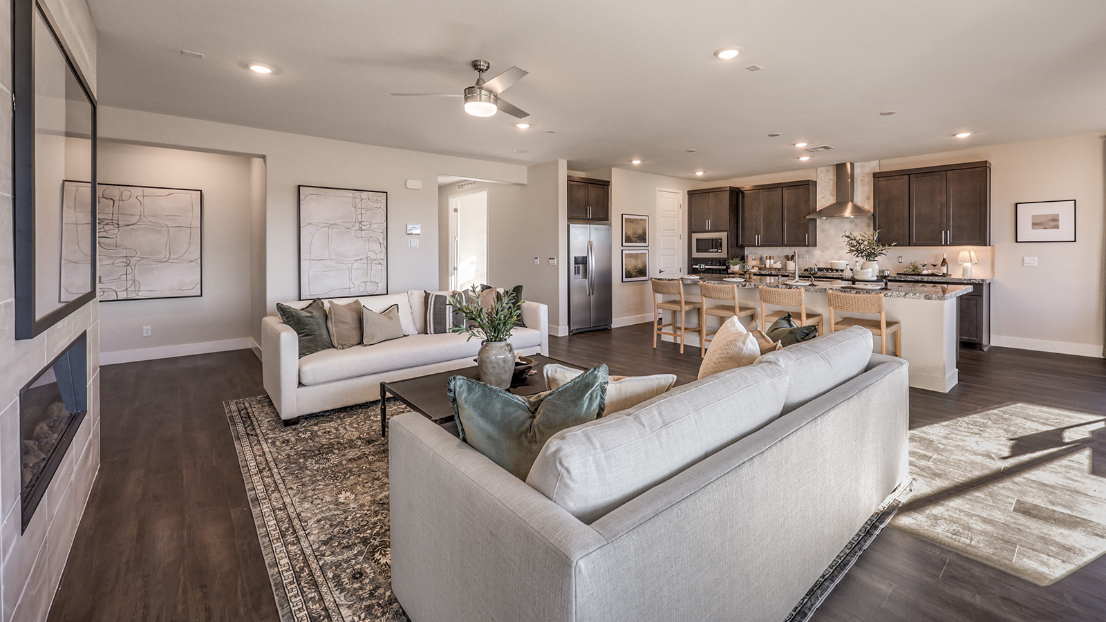 The Majestic Hills 2650 Plan Great Room featuring Luxury Vinyl Plank flooring, a modern ceiling fan, and a large sliding glass door that opens to the backyard. This spacious and open layout offers abundant natural light and seamless flow to adjoining areas, ideal for everyday living and entertaining.