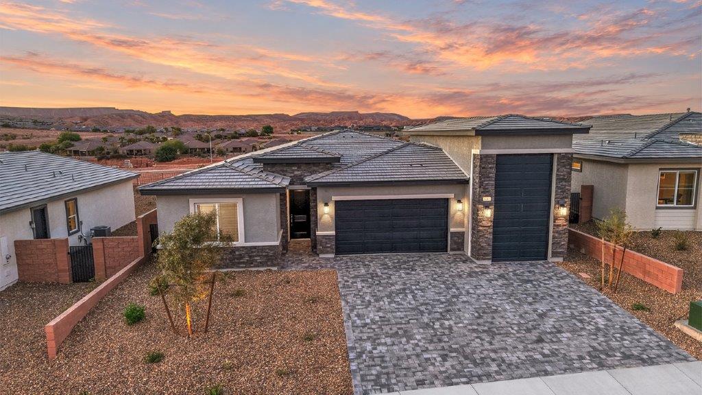 Our 2650 model home in the Majestic Hills community with gray and blue exterior paint schemes, a flat tile roof, front yard landscaping, paver walkways, and a 2-car garage with a Recreation Garage.