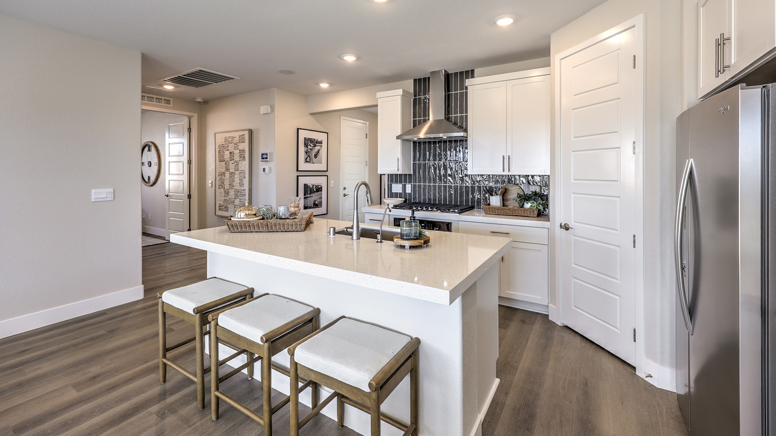Our 1617 model kitchen in the Majestic Hills Community with white shaker style cabinets, quartz countertops, a kitchen island, and Whirlpool Stainless Steel appliances.