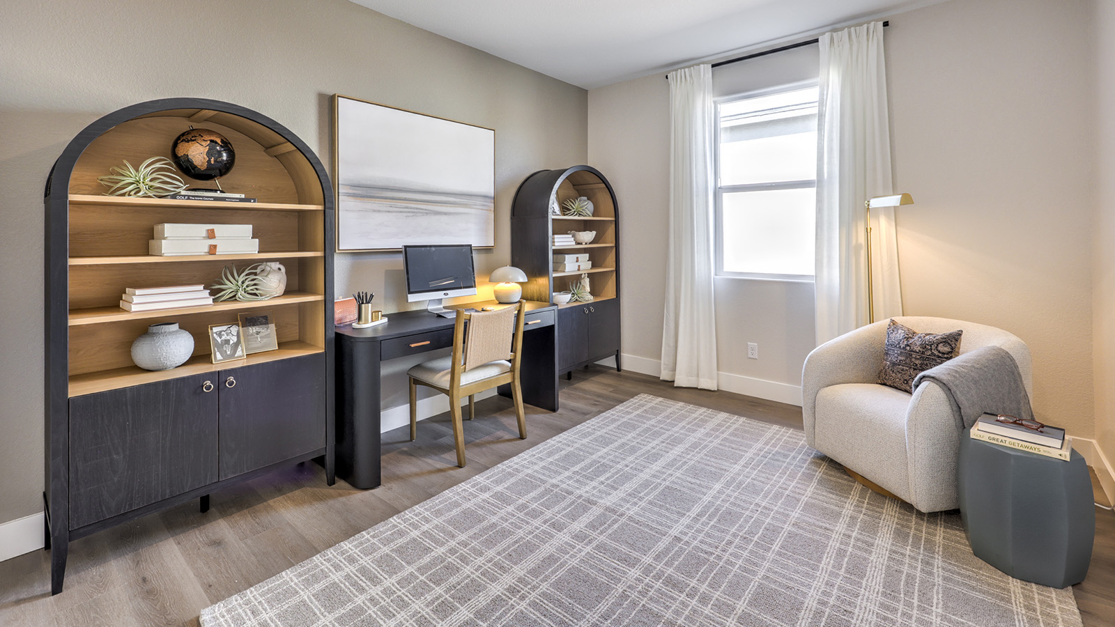 The Office/Bedroom Two option in our Majestic Hills 1617 model with carpet flooring and a window, furnished with a desk and chair.