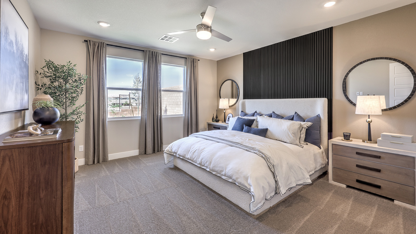 The Bedroom One Suite in our Majestic Hills 1870 model with carpet flooring, large windows, and recessed ceiling lights.