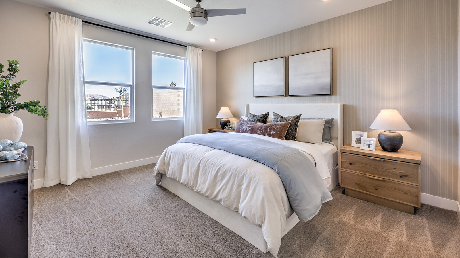 The Bedroom One Suite in our Majestic Hills 1617 model with carpet flooring, windows, and recessed ceiling lights.
