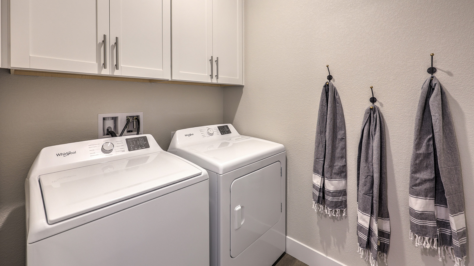 Our Majestic Hills 1617 model laundry room with a shelf and washer and dryer.