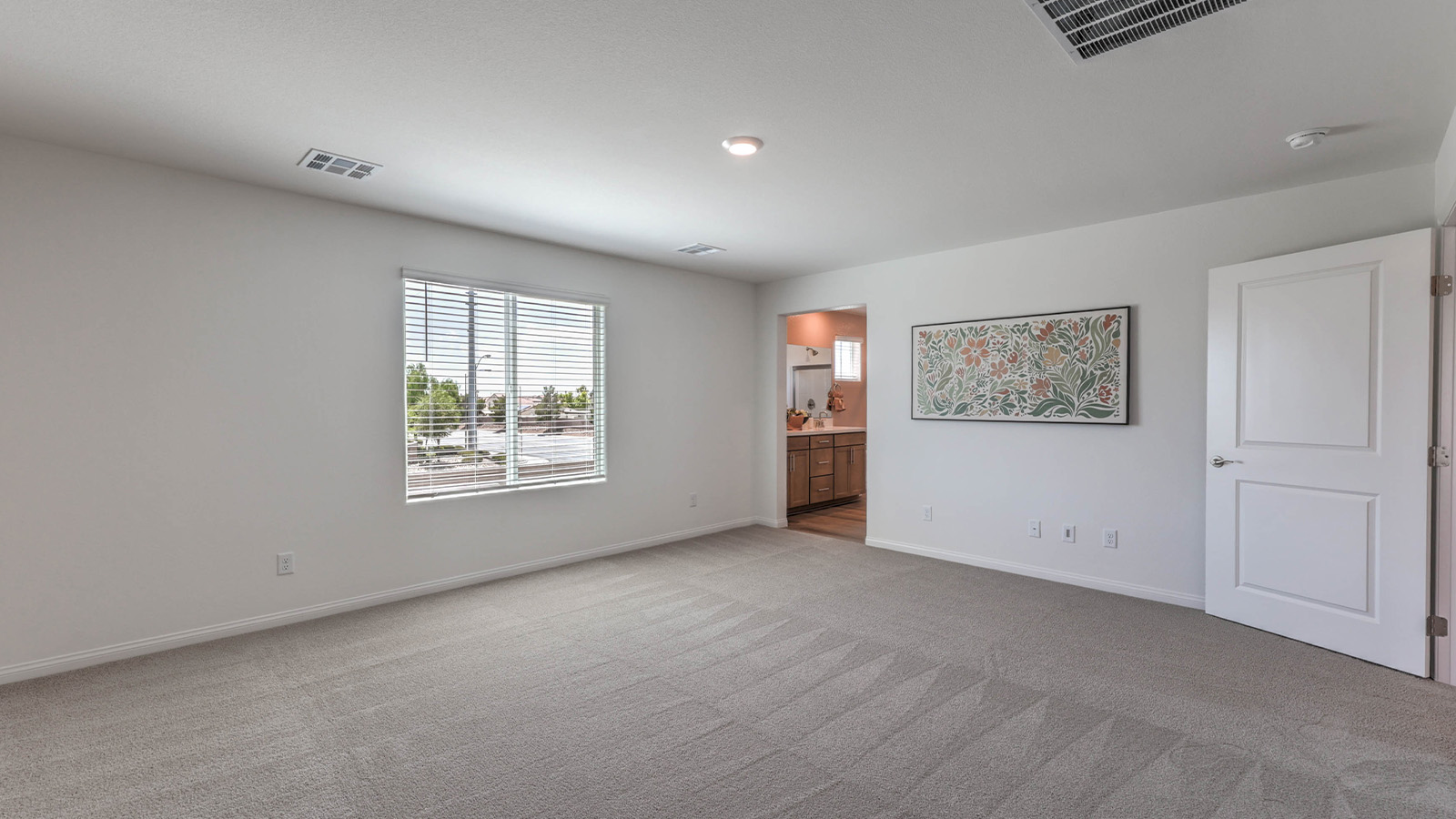 The Bedroom One Suite in our Sky Falls 2660 model with carpet flooring, ceiling fan with a light kit, and large windows.