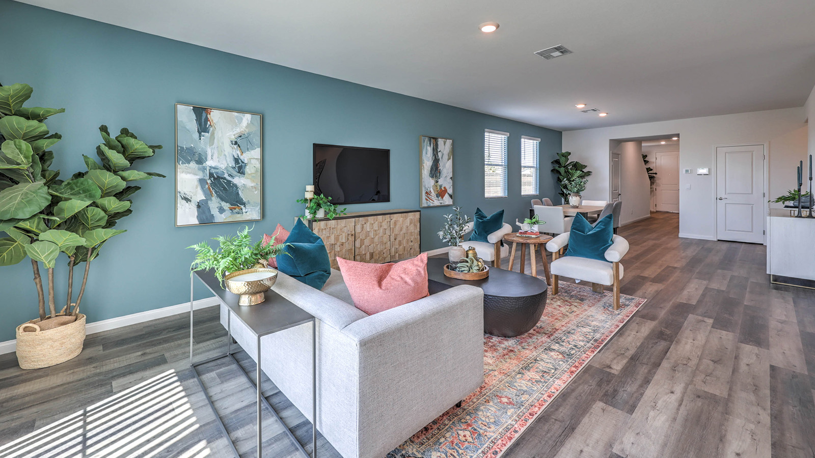 The dining room and great room in our Sky Falls Plan features an open-concept design with 9-foot flat ceilings and luxury vinyl plank flooring. The dining area is spacious, with a large window allowing natural light to fill the space. Adjacent to it, the great room offers a bright and airy feel, enhanced by additional windows and sliding glass doors leading to the backyard. The seamless flow between these areas creates a welcoming and functional living space.