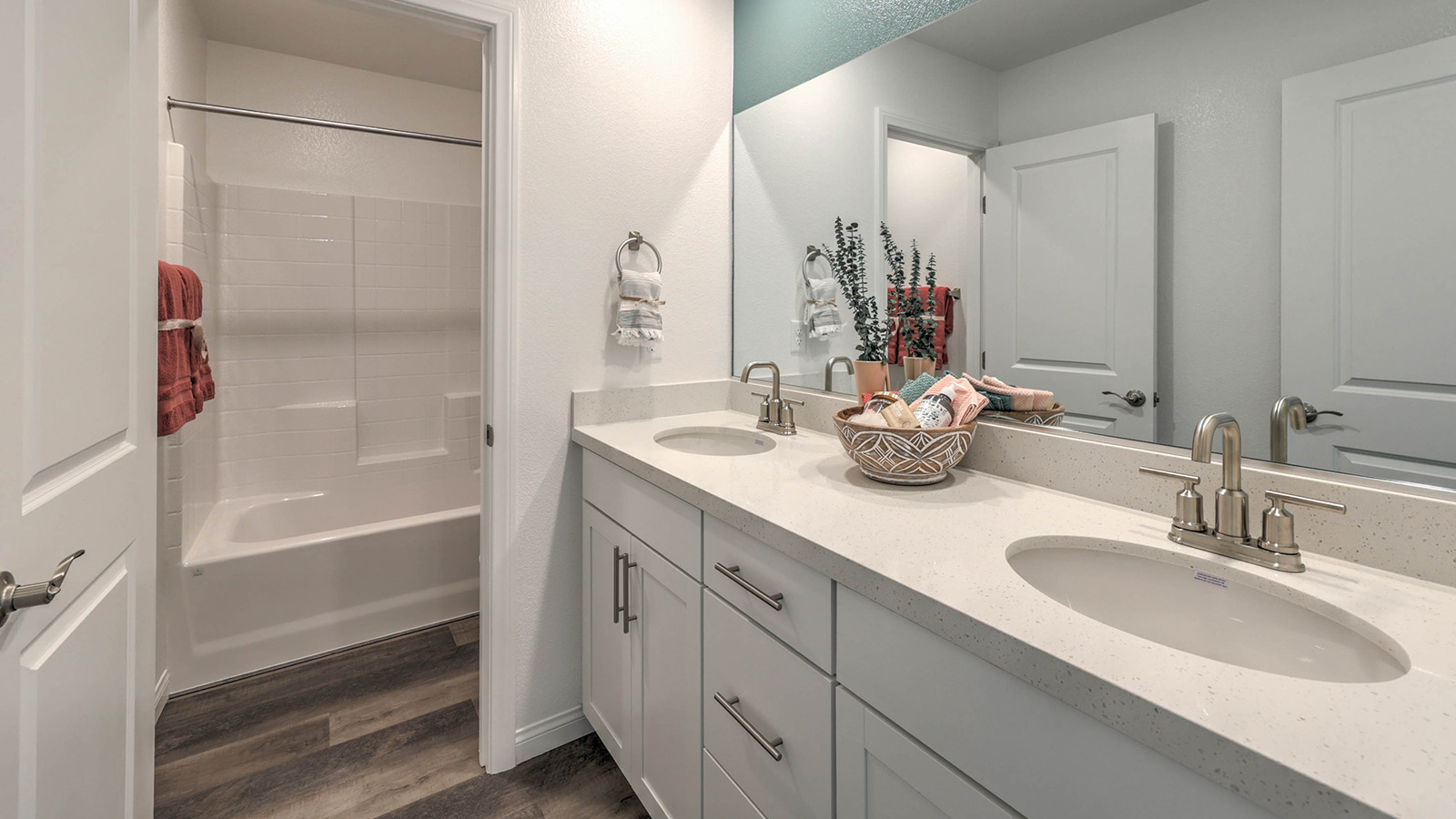 Bathroom Two in our Sky Falls 3000 model with quartz countertops at the Bath Vanity, a walk-in shower, mirror, and white cabinets.