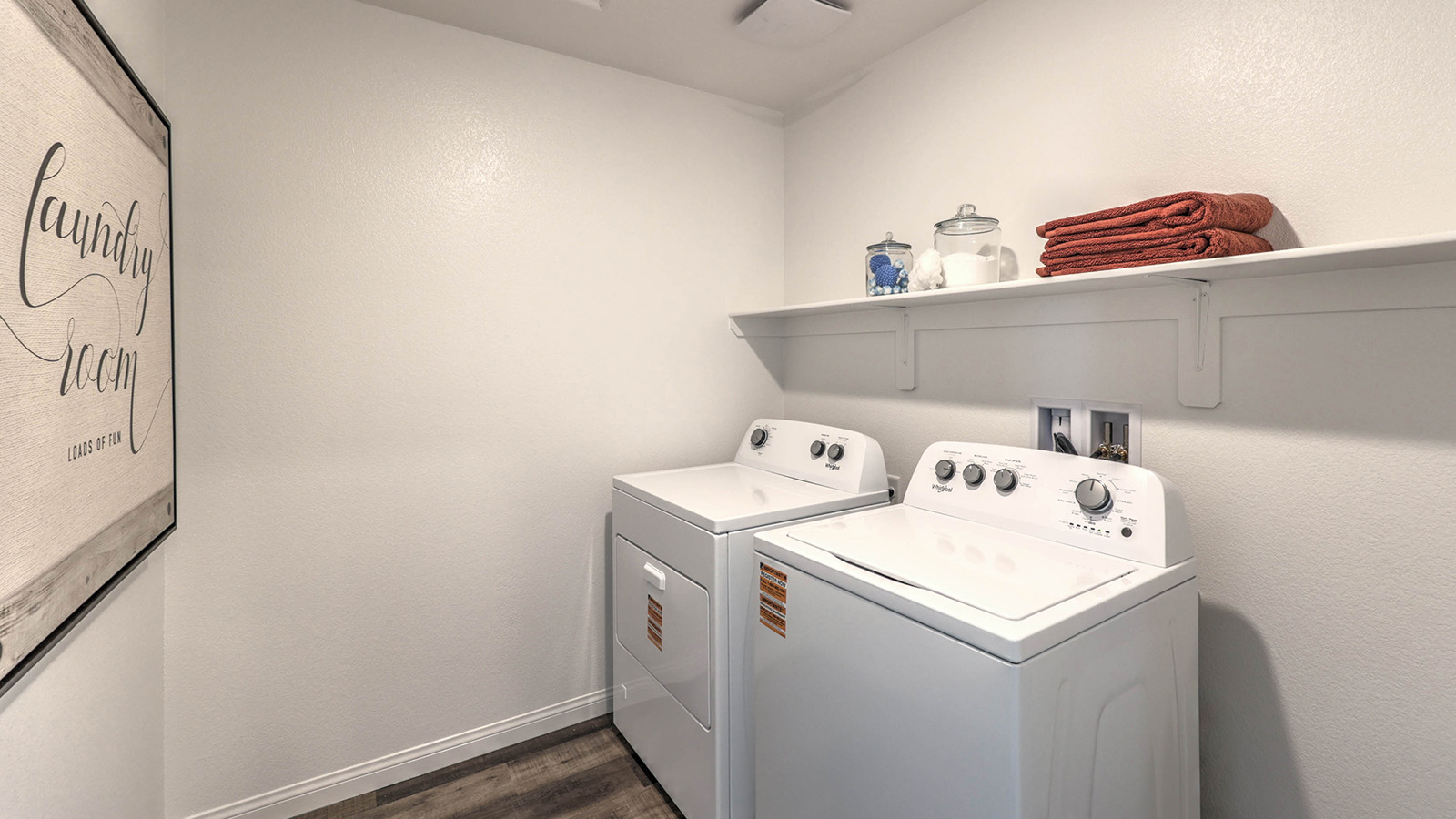 Our Sky Falls 3000 model laundry room with a shelf and a washer and dryer.