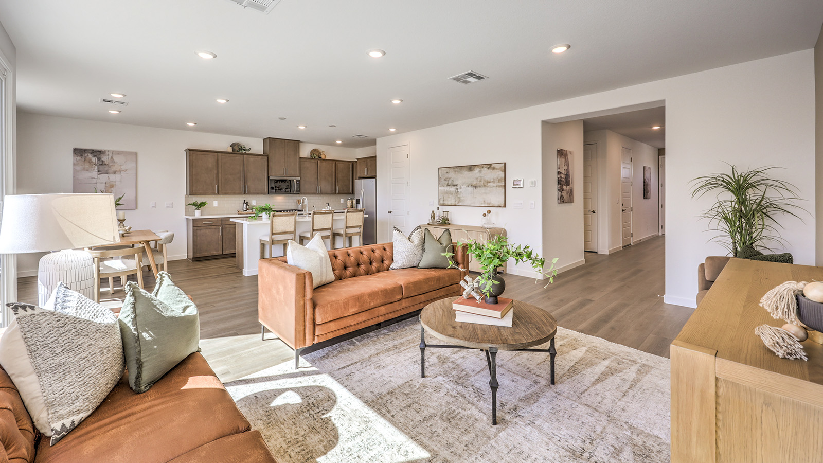 The Arabella Falls 2660 Plan open concept Great Room with luxury vinyl flooring, large windows, and a sliding door to the backyard.