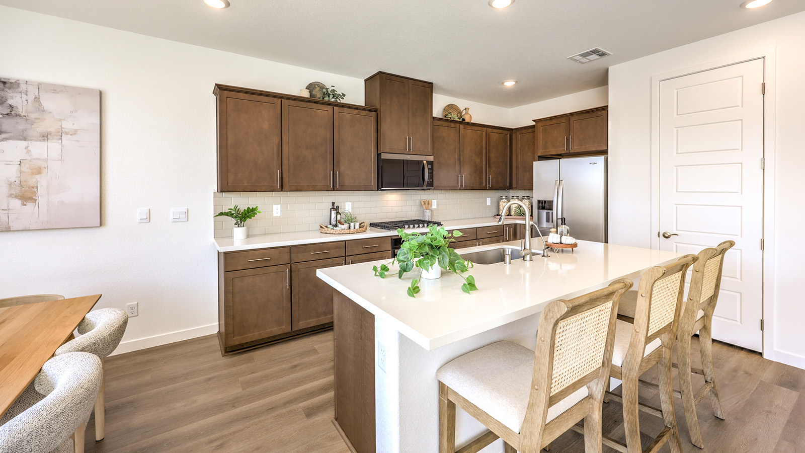 Our 2660 model kitchen in the Arabella Falls Community with white shaker style cabinets, Quartz countertops, a kitchen island, and Whirlpool Stainless Steel appliances.