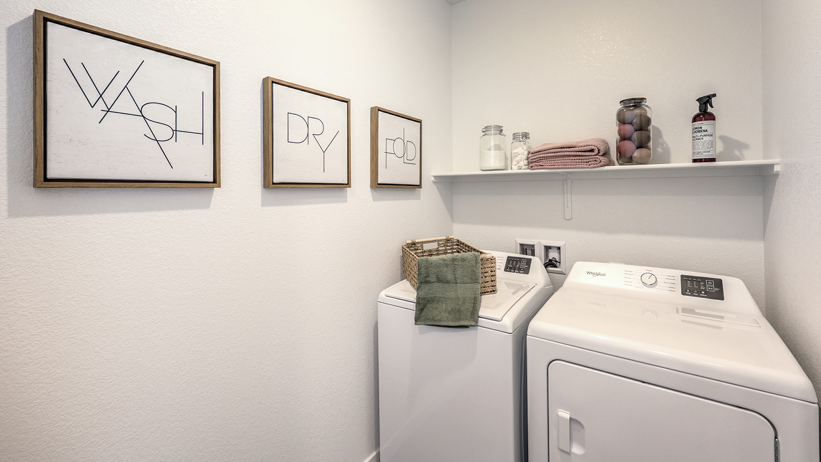 Our Arabella Falls 2660 model laundry room with shelves and a washer and dryer.