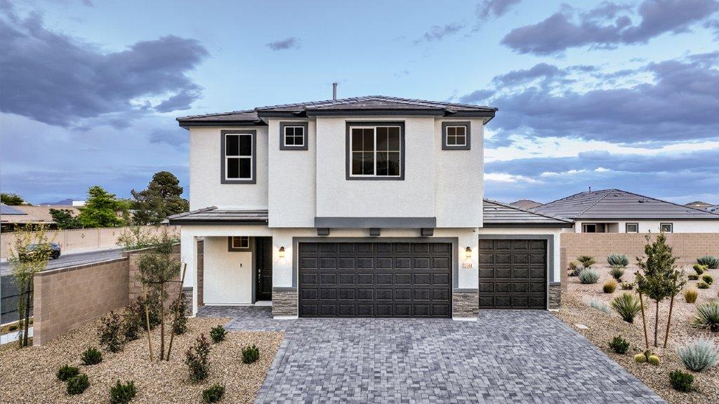 Our 2660 model home in the Arabella Falls community with black and white exterior paint schemes, a flat tile roof, front yard landscaping, 3-car garage, and paver walkways