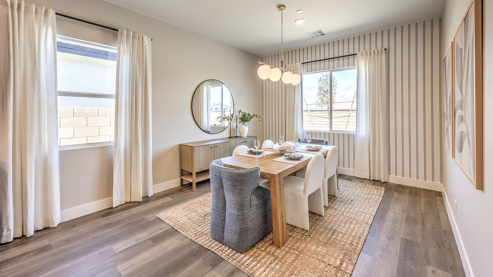 The dining room and great room in our Heartlnad Manor 2538 Plan features an open-concept design with 9-foot flat ceilings and luxury vinyl plank flooring. The dining area is spacious, with a large window allowing natural light to fill the space. Adjacent to it, the great room offers a bright and airy feel, enhanced by additional windows and sliding glass doors leading to the backyard. The seamless flow between these areas creates a welcoming and functional living space.