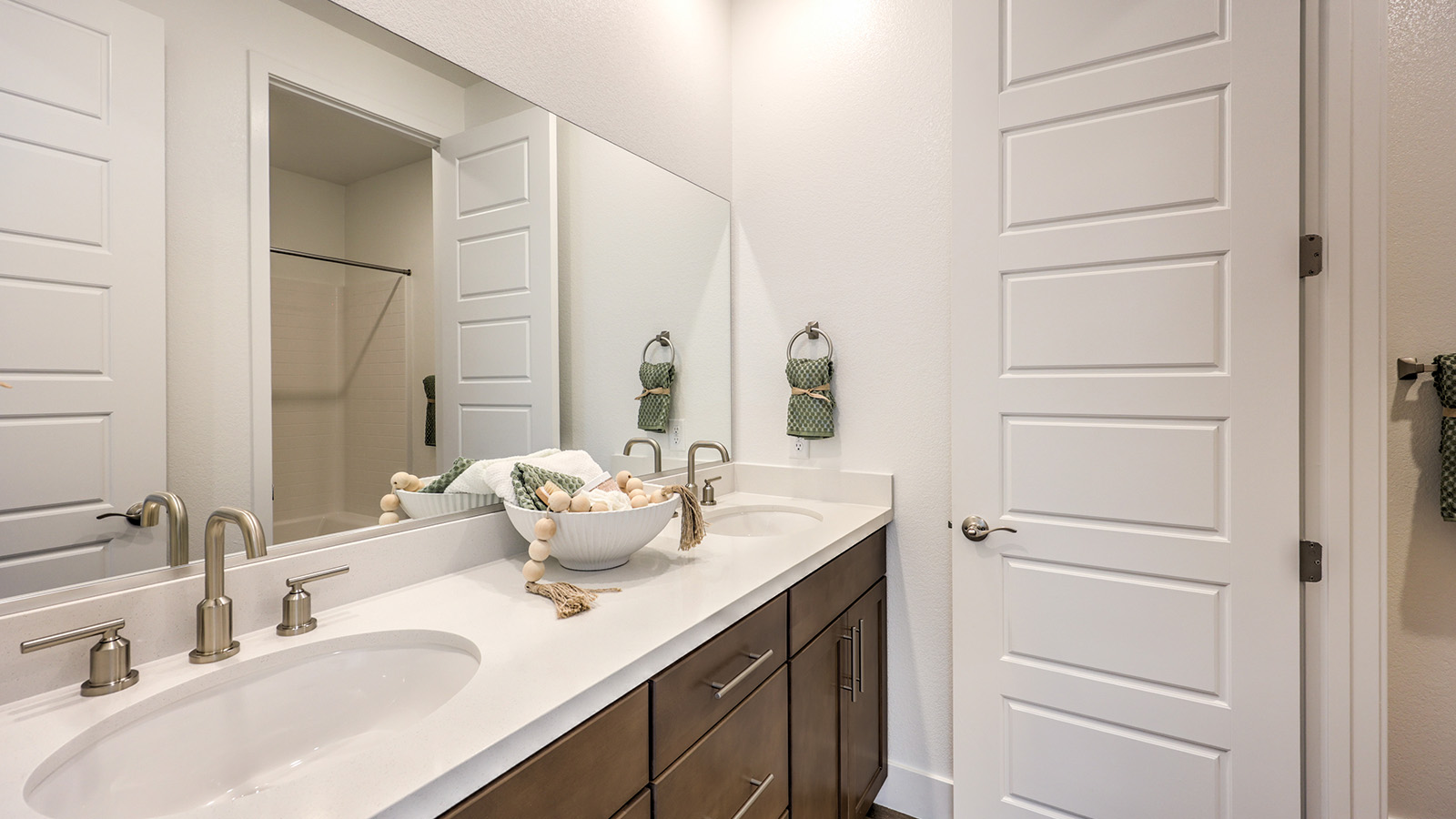 Bathroom Two in our Serenity 2660 model with Granite countertops at the double Bath Vanity, a walk-in shower, mirror, and grey cabinets.