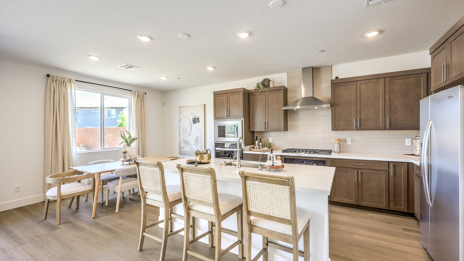 Our 2660 model kitchen in the Serenity Community with grey shaker style cabinets, Granite Slab countertops, a kitchen island, and Whirlpool Stainless Steel appliances.