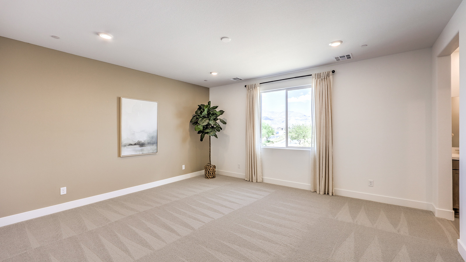 The Bedroom One Suite in our Serenity 2660 model with carpet flooring, ceiling fan with a light kit, and large windows.