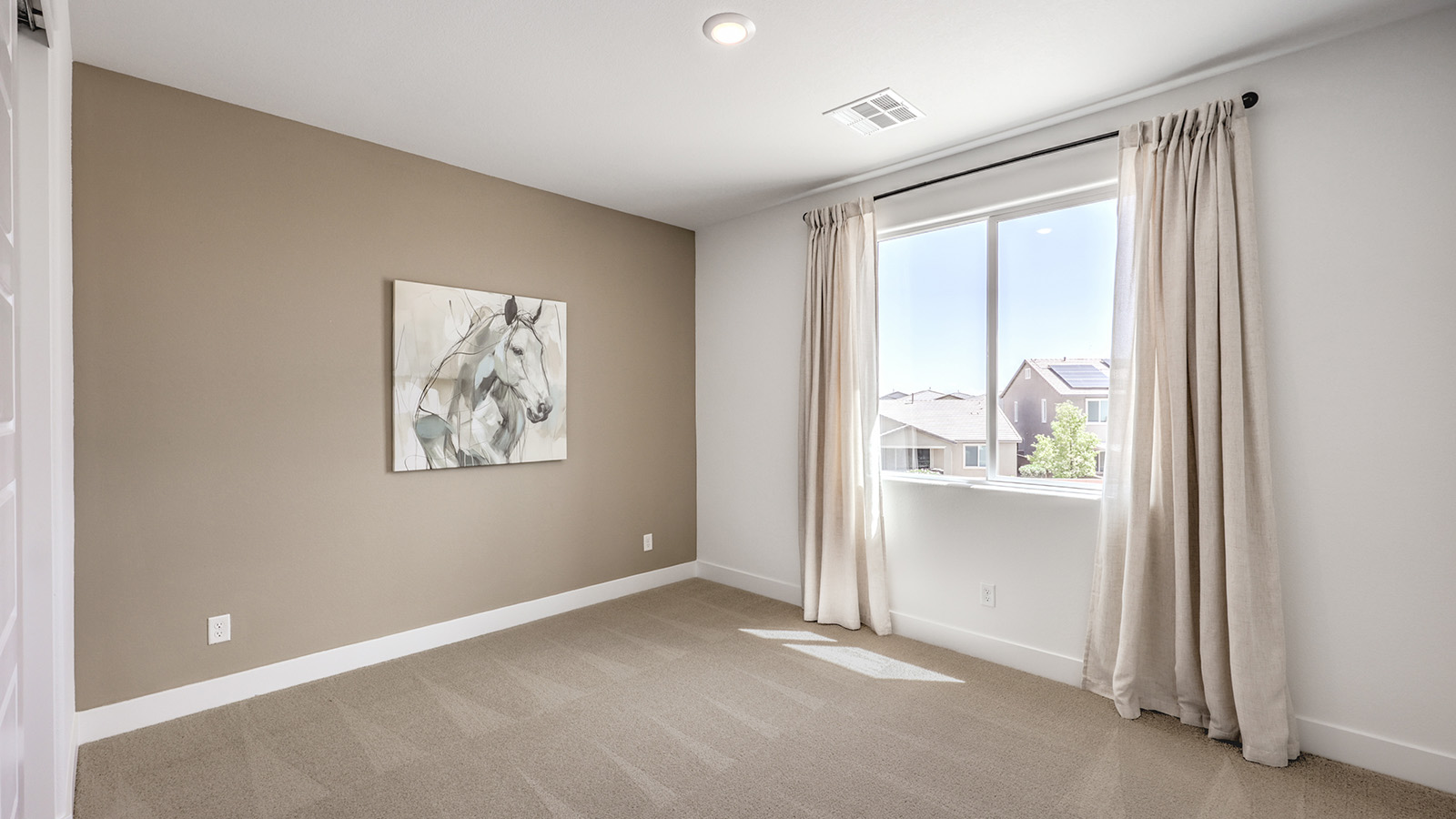 Bedroom Two in our Serenity 2660 model with carpet flooring, a sliding closet, and a window.