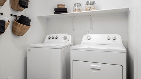 Separate laundry room with shelf above washer and dryer