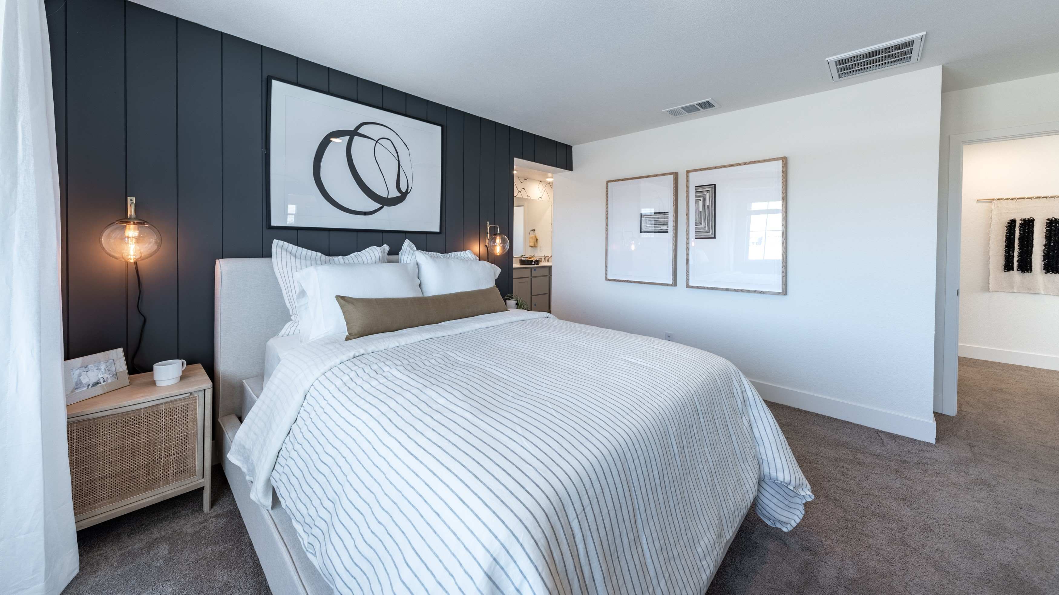 Primary bedroom with a king sized bed and modern accent wall
