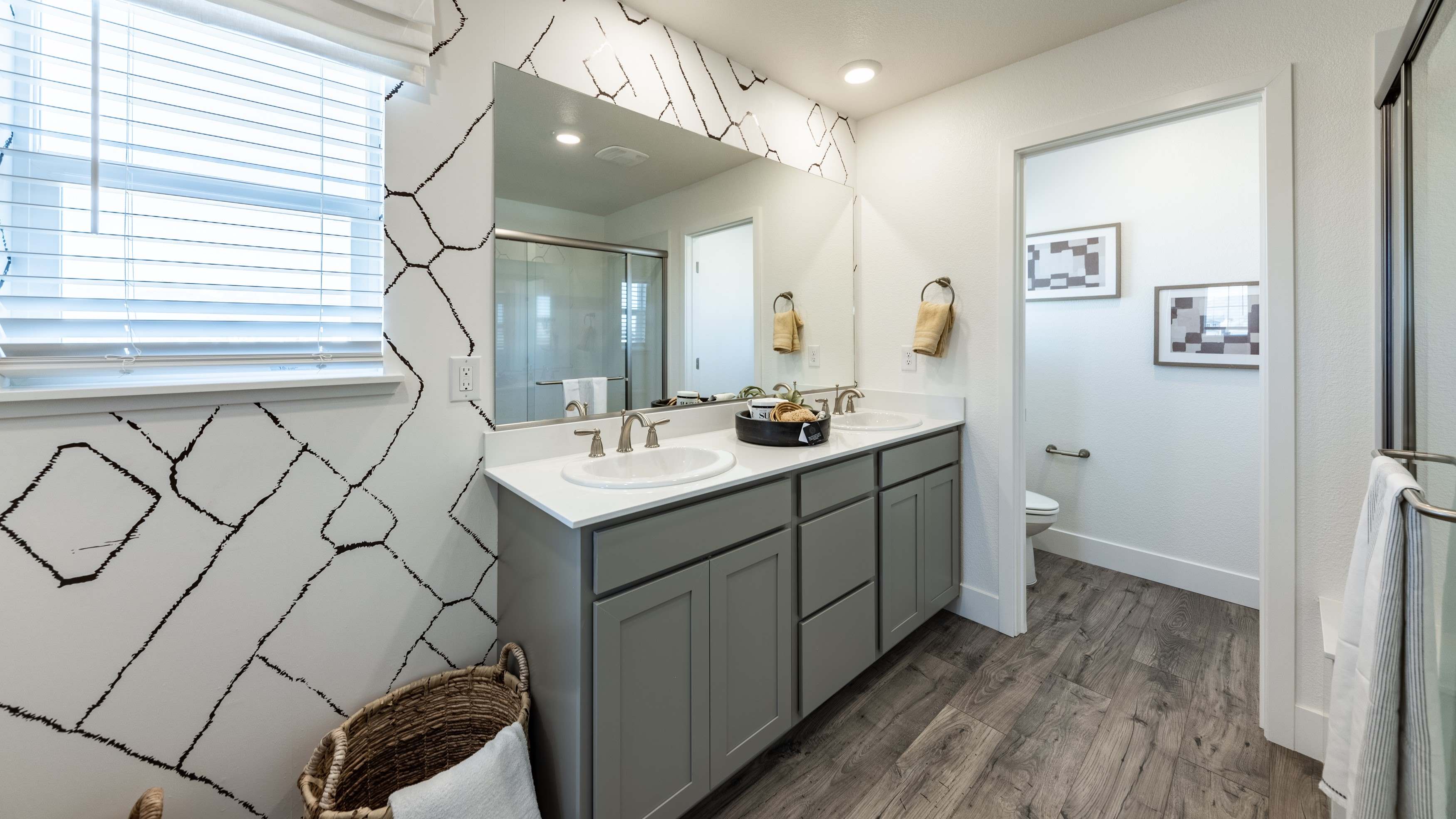 Modern primary bathroom with separate room for the toilet and a double vanity