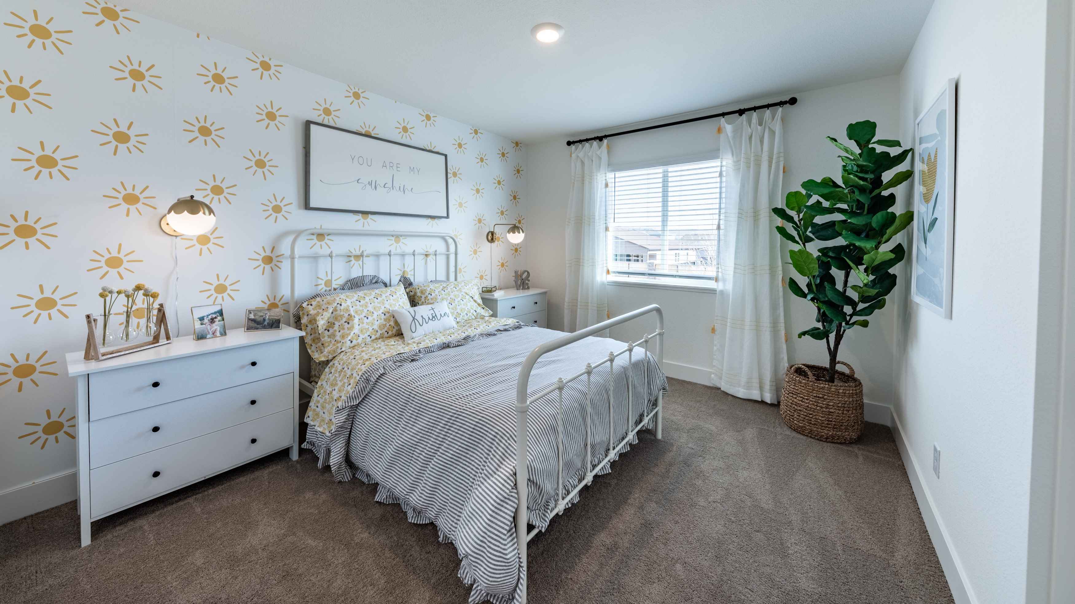 Carpeted secondary bedroom with a large window to let in natural light