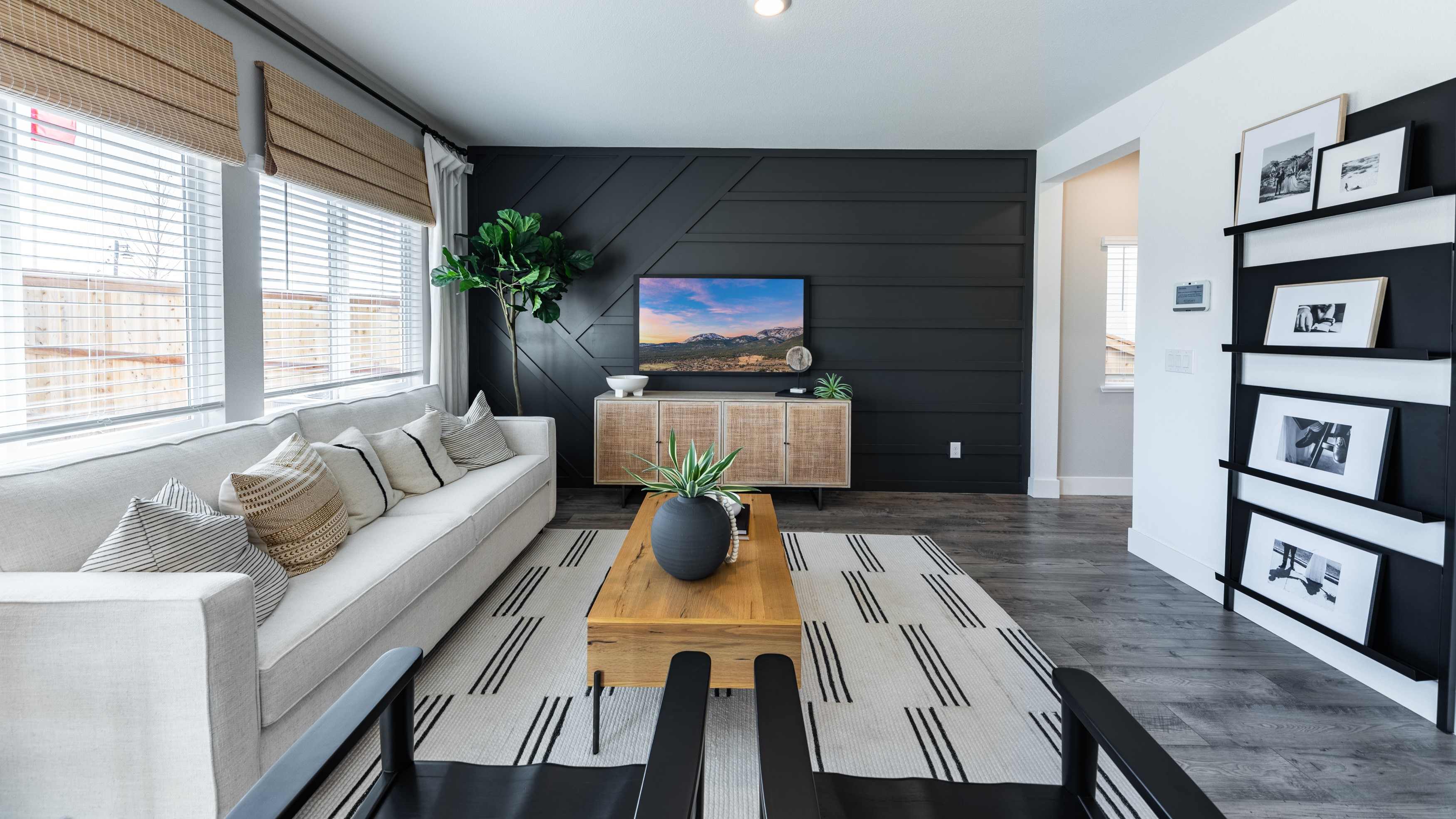 Modern living room with large windows looking out into back yard of the home