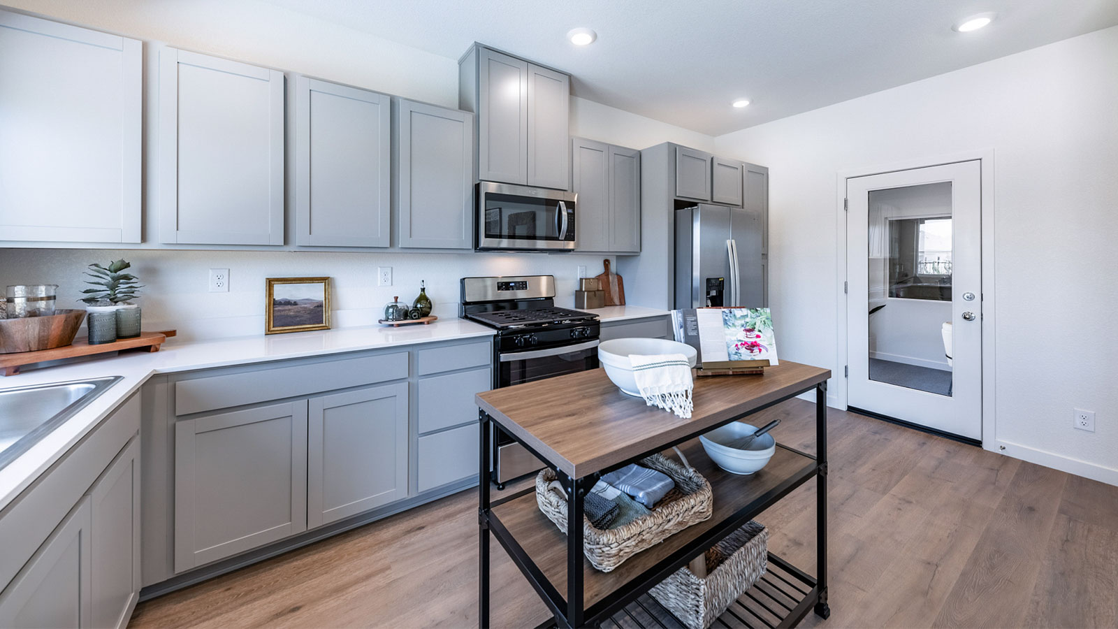 Kitchen with modern grey shaker-style cabinets next to garage entry to the home