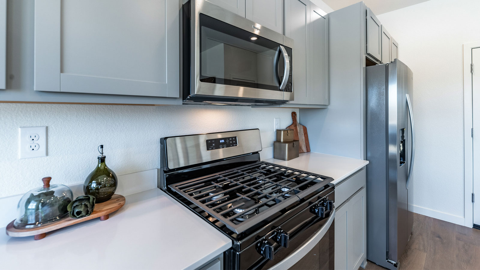 Stainless steel microwave, stove, and refrigerator in kitchen