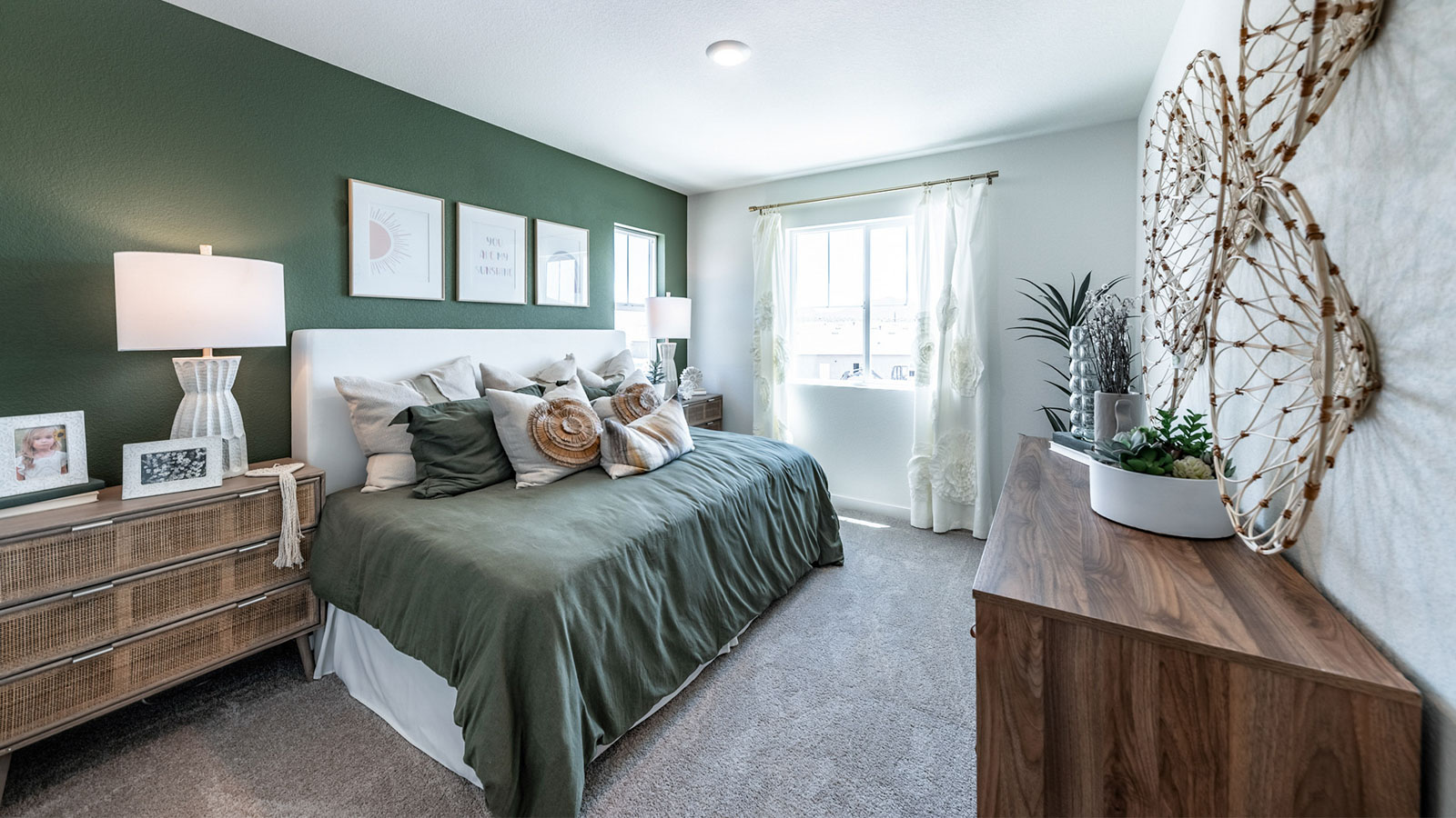 Carpeted secondary bedroom with large windows to let in natural light