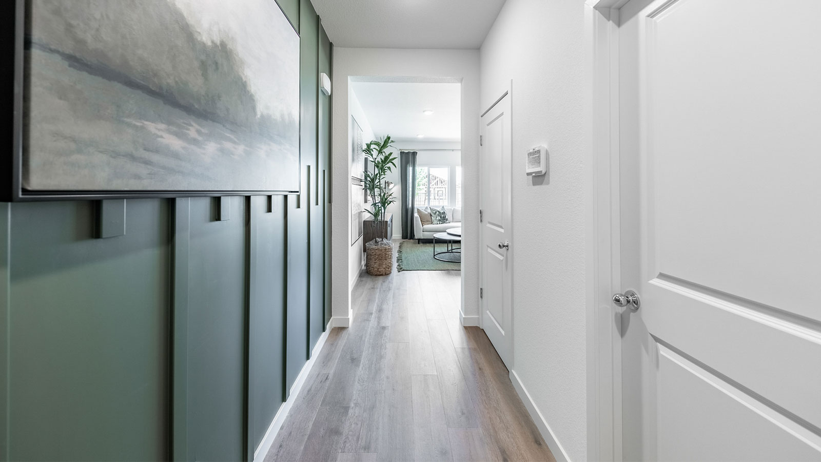 Hallway leading to living area with half bathroom in entry