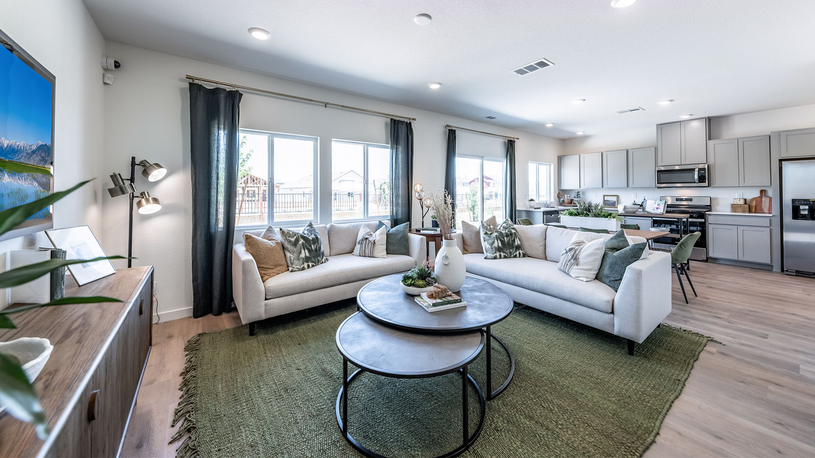 Open concept living area with large windows looking out into backyard of the home