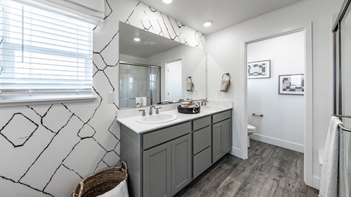 Modern primary bathroom with separate room for the toilet and a double vanity
