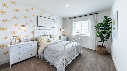 Carpeted secondary bedroom with a large window to let in natural light