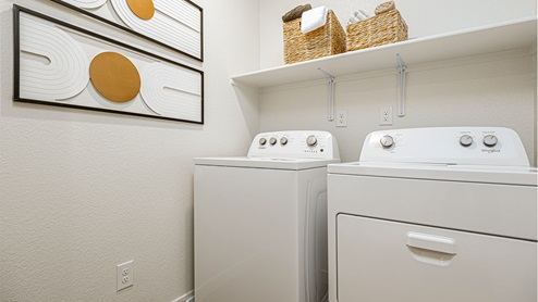 Laundry room with shelf above laundry machines