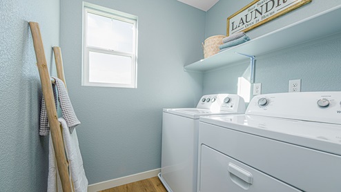 Laundry room with small window and shelf above washer and dryer