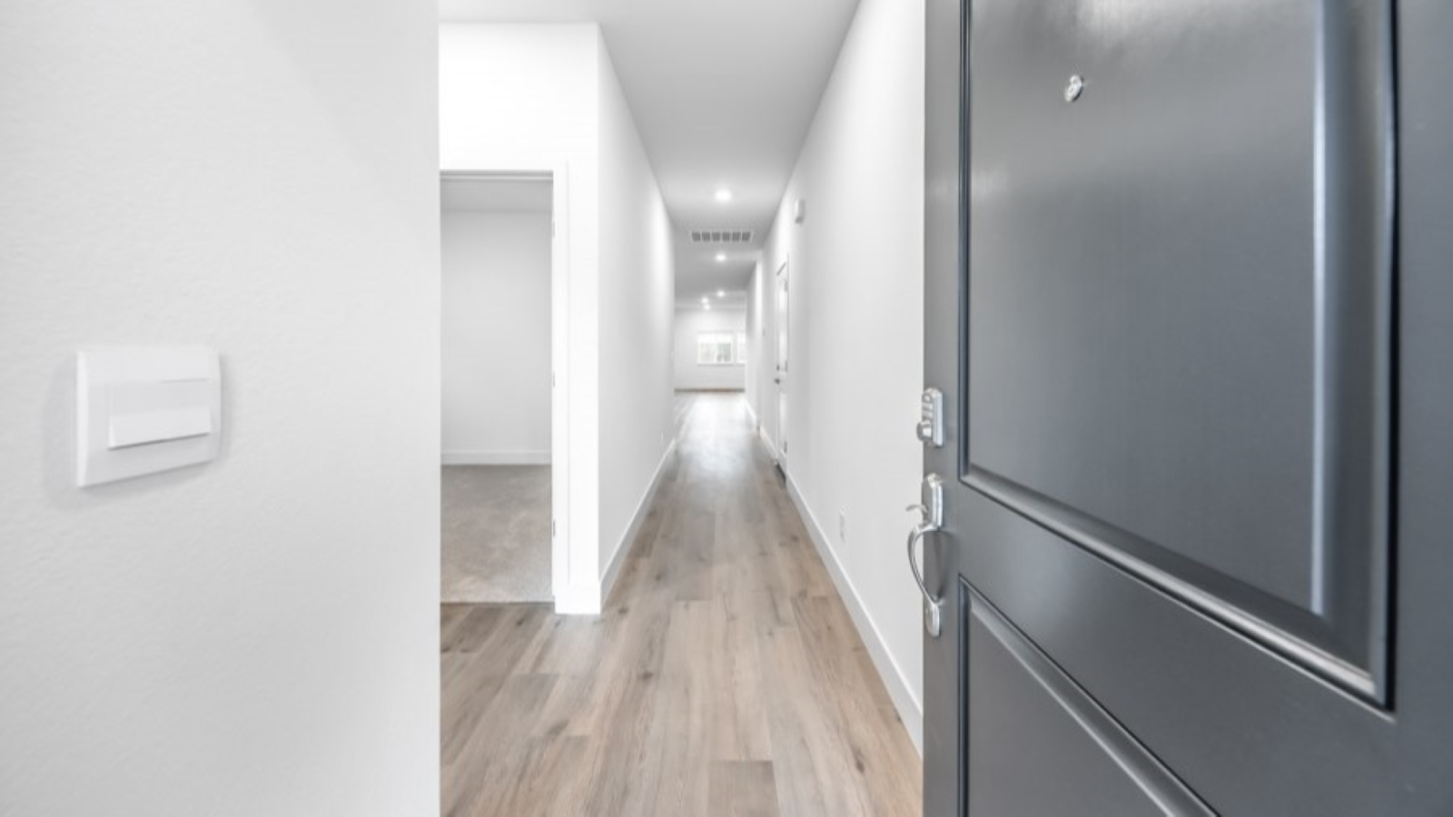 Home entry hallway with second bathroom and bedroom to the left