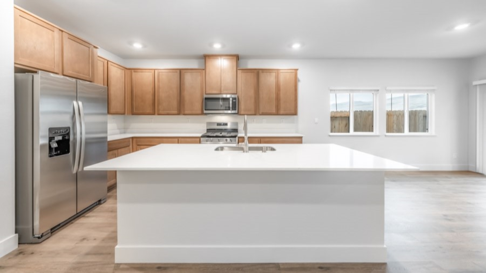 Kitchen with an island, white shaker-style cabinets and stainless steel appliances
