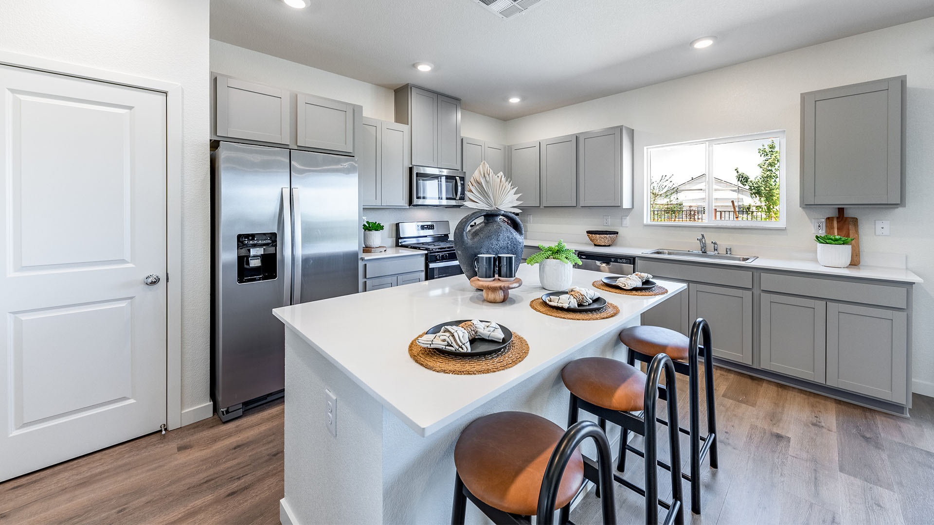 Modern kitchen with island, pantry and stainless steel appliances
