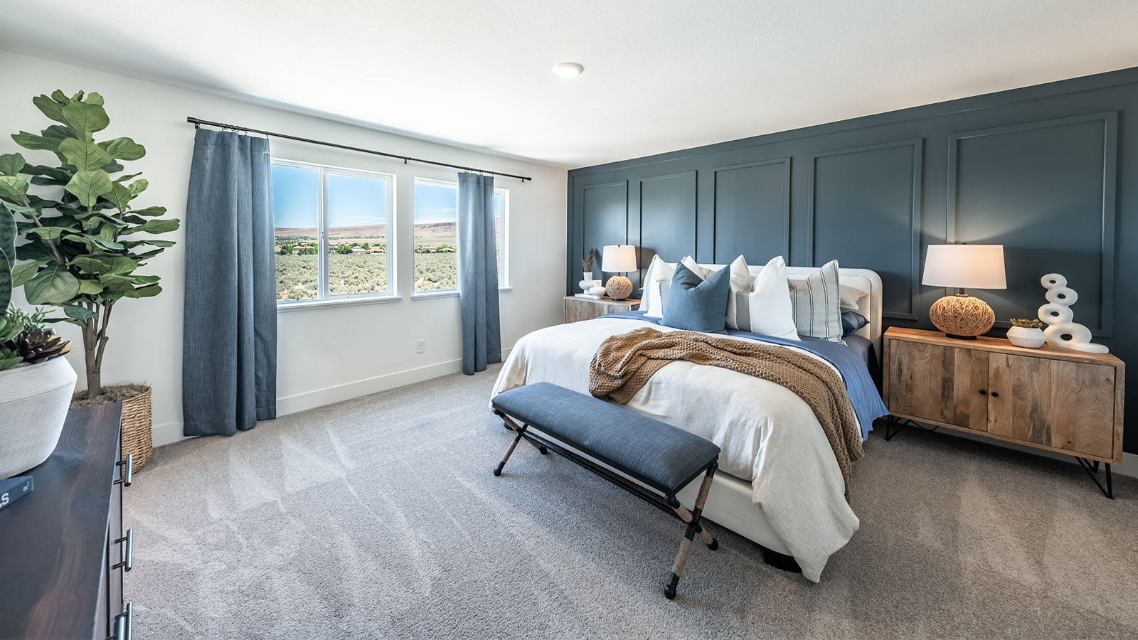 Large primary bedroom with large windows letting in plenty of natural light