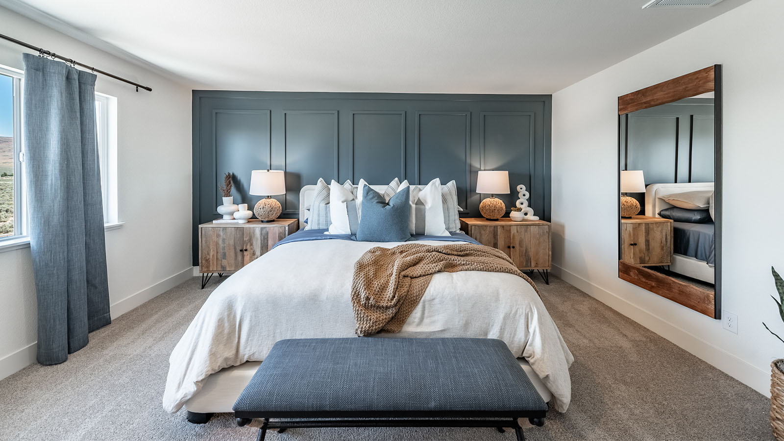 Carpeted primary bedroom with large windows and attached bathroom